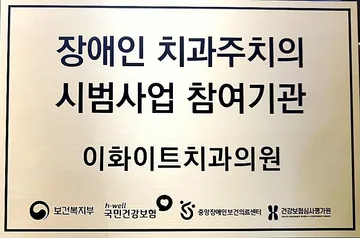 보건복지부 장애인 치과주치의 시범사업 참여기관 명판 — 이화이트치과의원